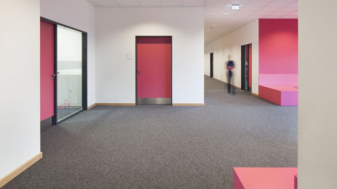 Carl-Friedrich-Gauß Oberschule Zeven Gang mit grauem Textilboden und Pinken Türen– Forbo Nadelvlies Markant